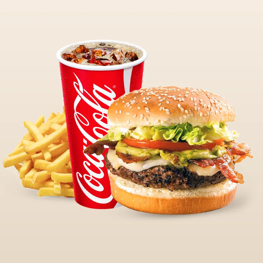 A Legends burger on a sesame bun with bacon, avocado, tomato and lettuce, beside fries and a fountain drink