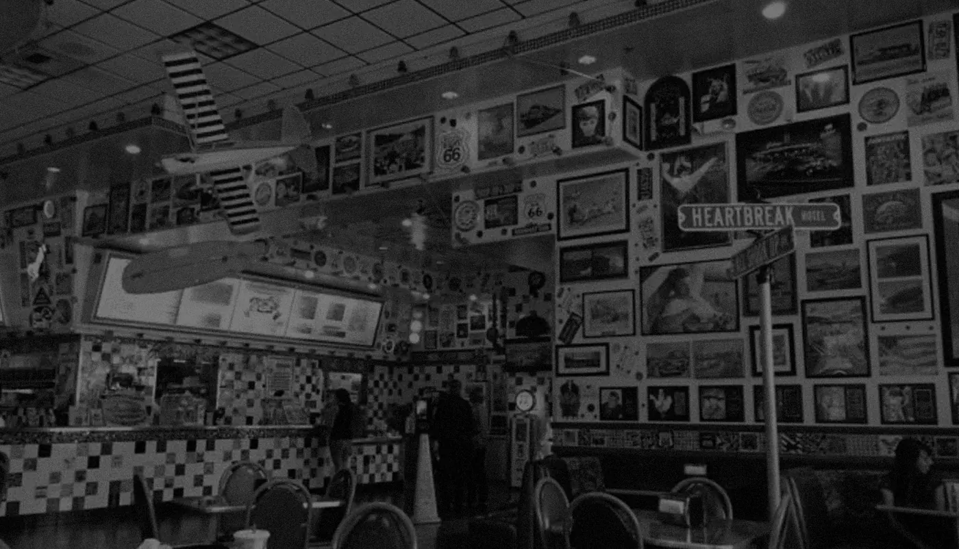 The counter at Legends, under a wall of framed photographs and signs,
                    with a black-and-white checkerboard tile front